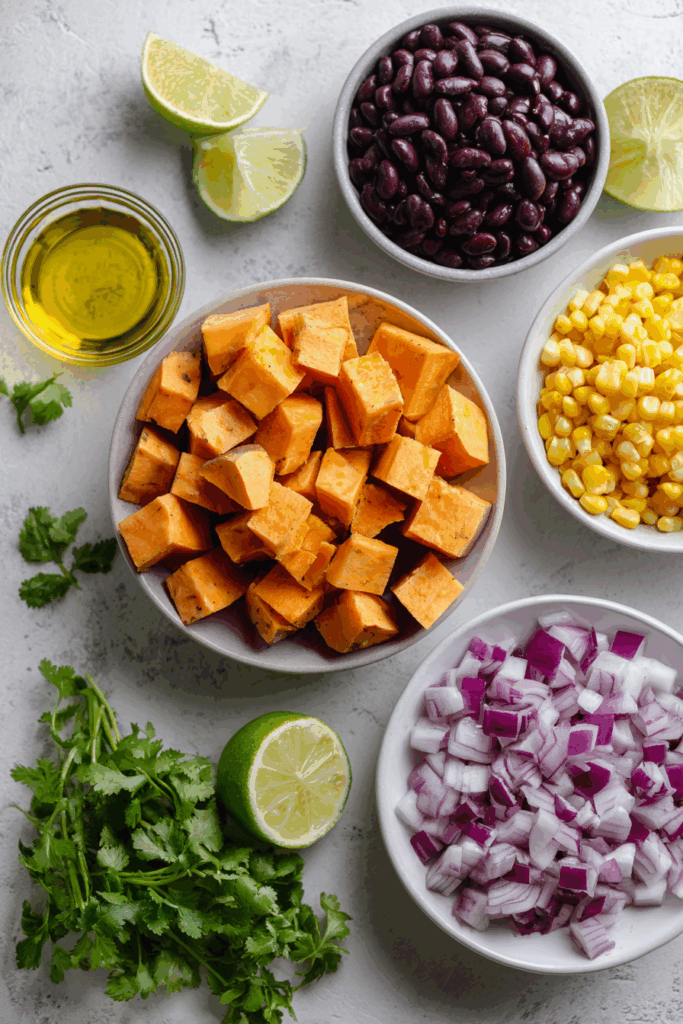 Ingredients for roasted sweet potato and black bean salad arranged on a table.