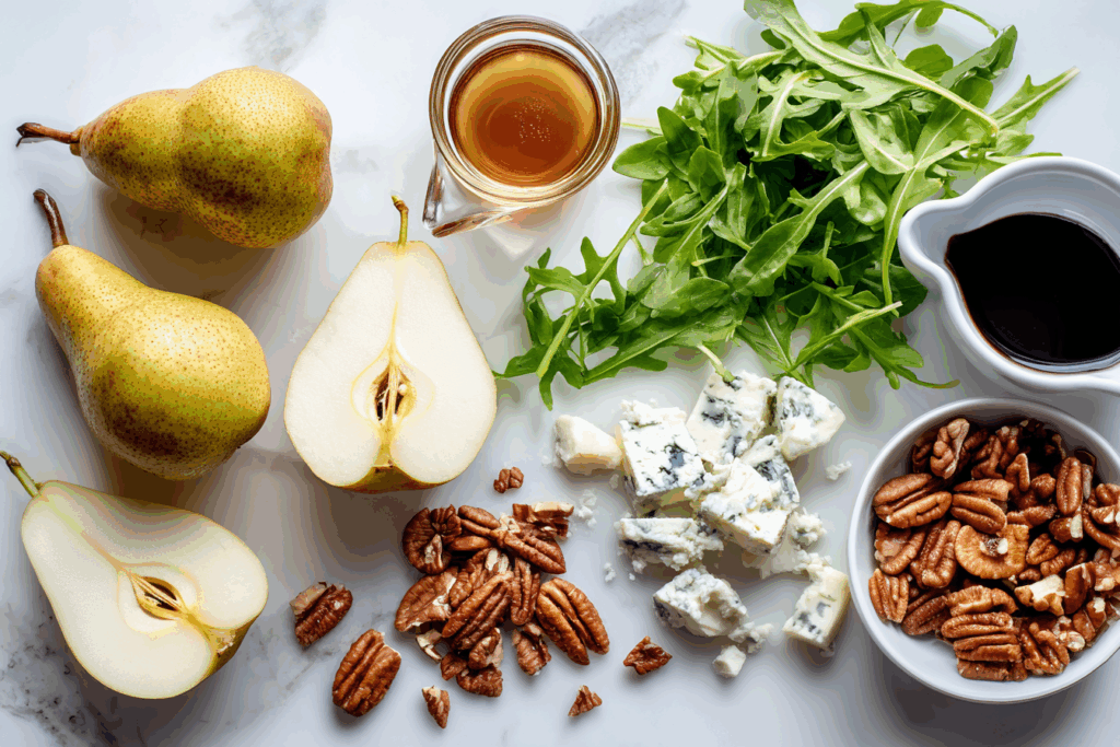 Ingredients for pear and gorgonzola salad laid out on a white table.
