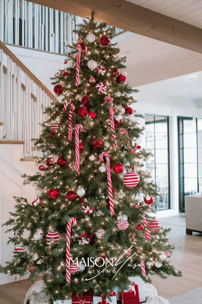 Christmas tree with red and white ornaments, candy cane ribbon, glowing fairy lights