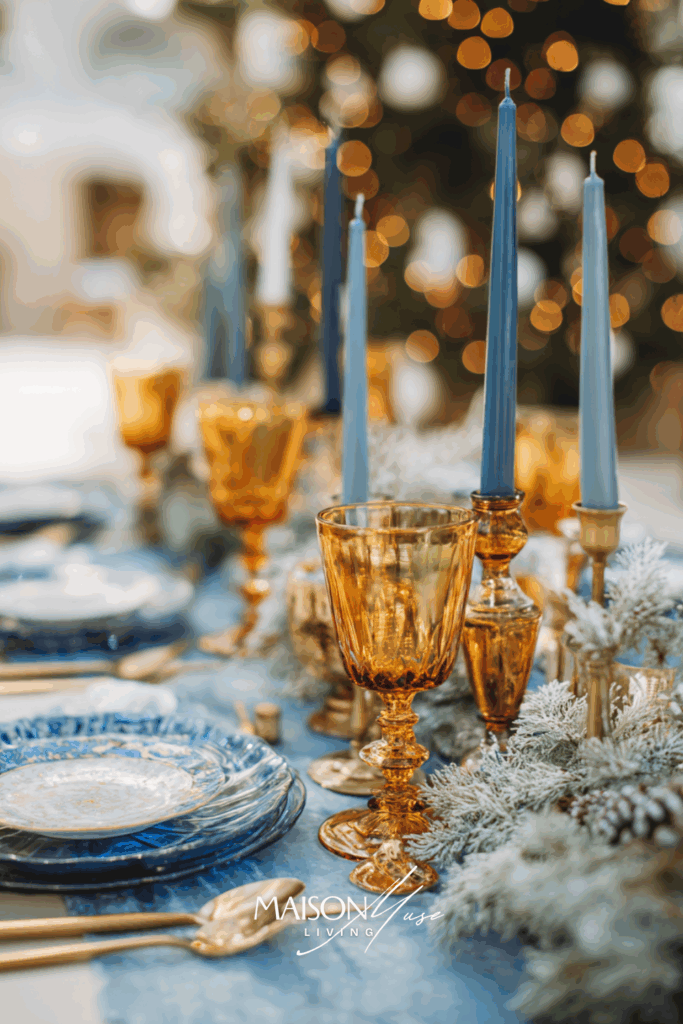 Christmas tablescape with amber glassware, gold cutlery, candles and frosted pine greenery