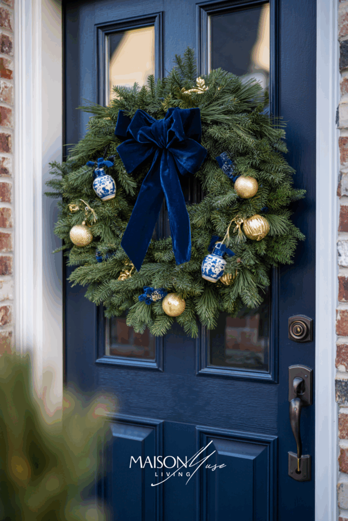dark navy front door with full evergreen Christmas wreath
